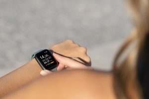 Ingezoomde foto van iemand die een smartwatch om zijn of haar pols draagt.